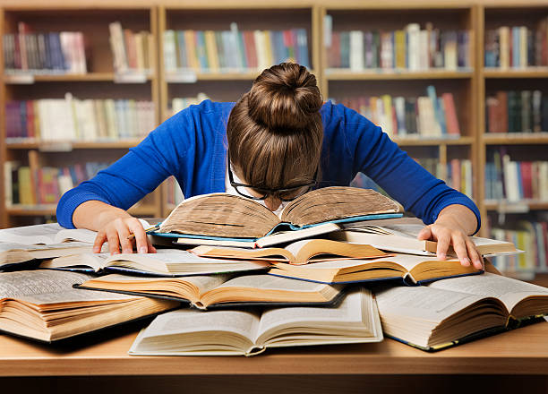 Student studying with multiple books to prepare for a competitive NUS MBA GMAT score